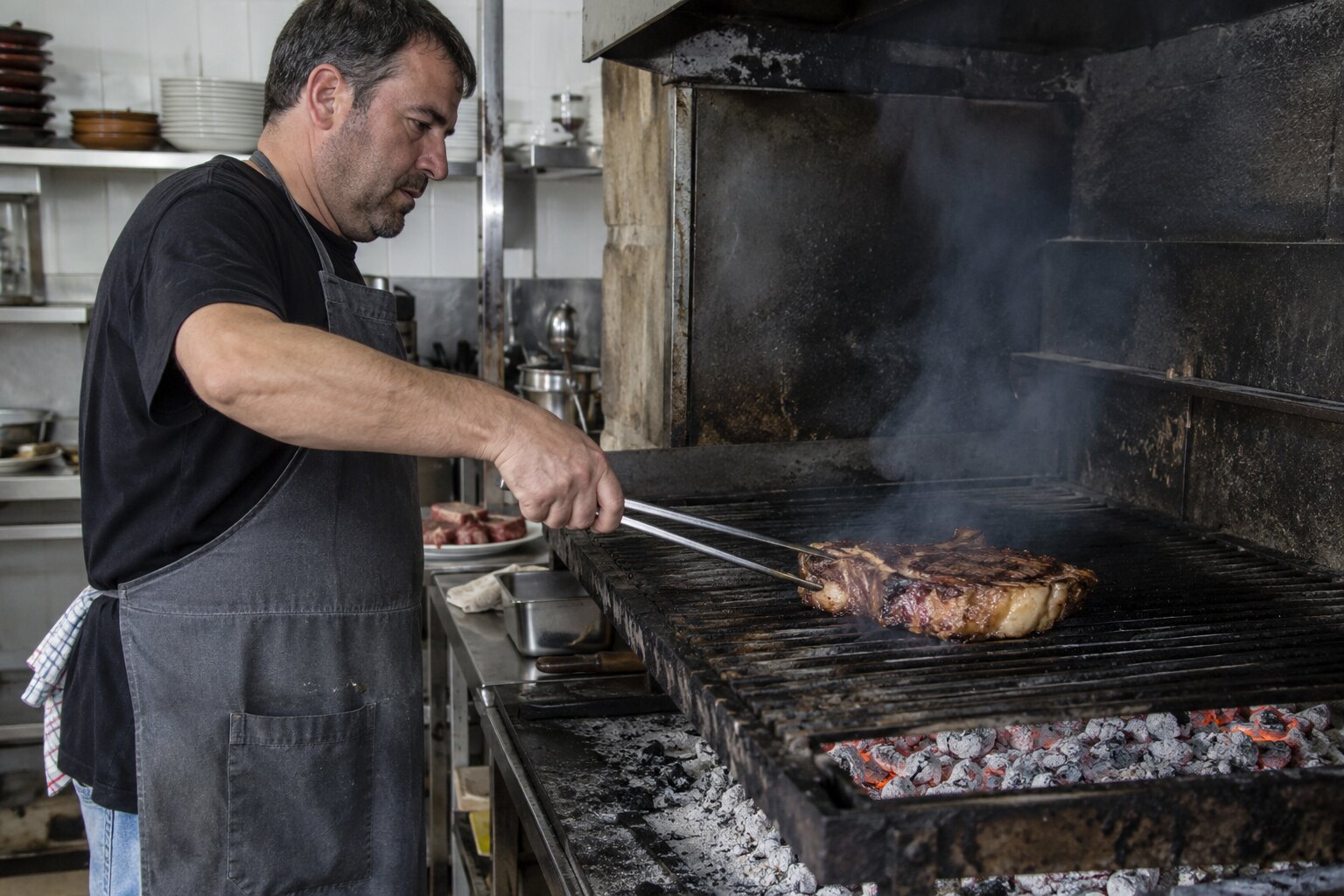 The grill at G cafe Bilbao, embers glowing under a thick Basque chuletón